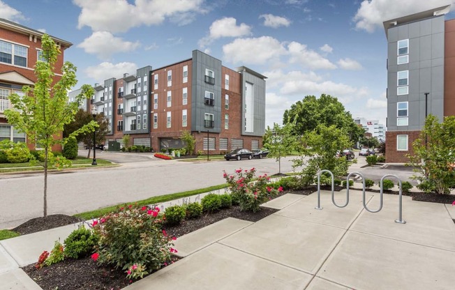 an exterior view of an apartment complex with a sidewalk and playground at 310 at Nulu Apartments-Student, Louisville, KY