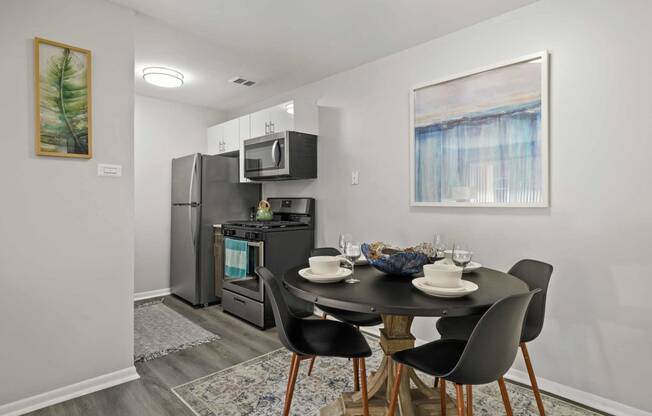 a kitchen with a table and chairs and a stainless steel refrigerator