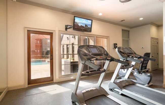 fitness room that overlooks pool at Village at Caldwell Mill Apartments in Birmingham, Alabama