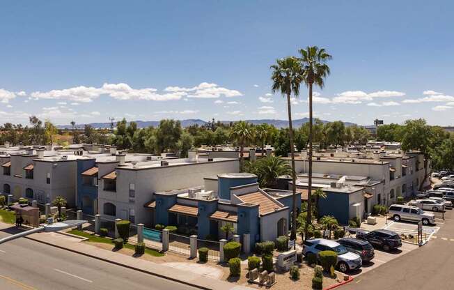 an aerial view of a row of apartment buildings and palm trees