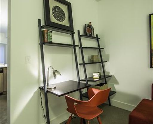 a room with a desk and a chair and a shelf