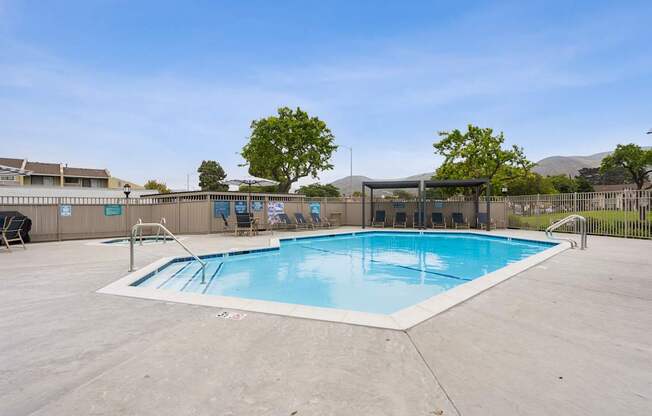 A large outdoor swimming pool with a diving board and lounge chairs.