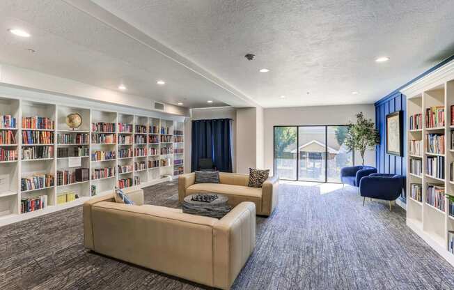 a living room with couches and chairs in front of a large bookshelf at The Beckstead, South Jordan, Utah