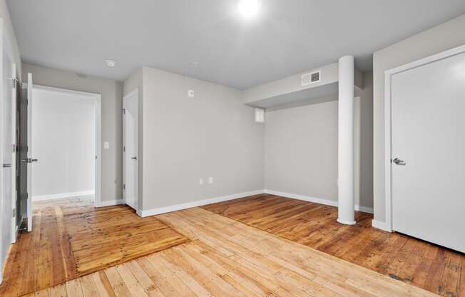 an empty living room with wood flooring and white walls at Spinning Mill Lofts, Clayton, NC 27520