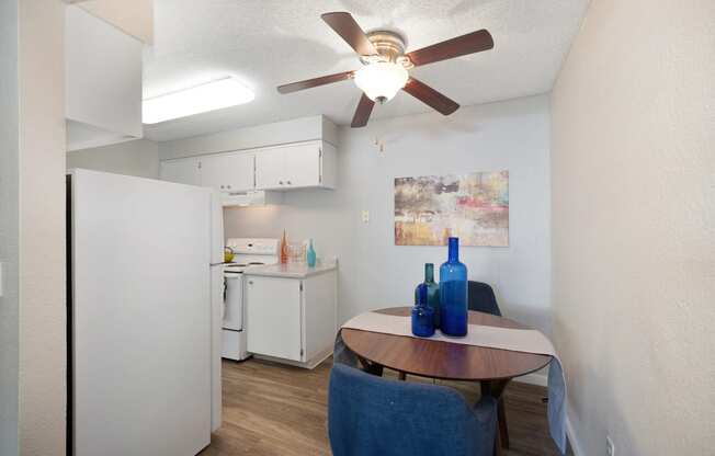 a kitchen and dining area with a table and a ceiling fan