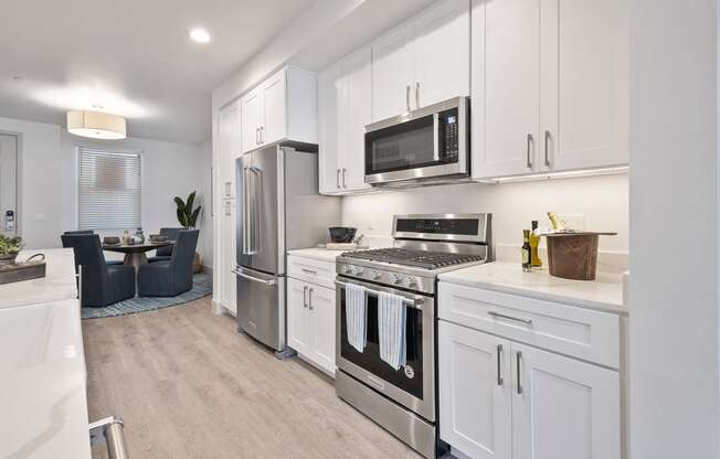 a kitchen with stainless steel appliances and white cabinets