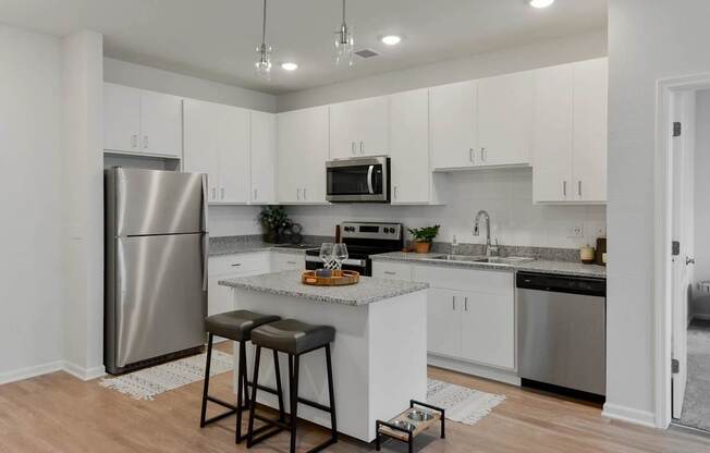 A kitchen with white cabinets and a stainless steel refrigerator.