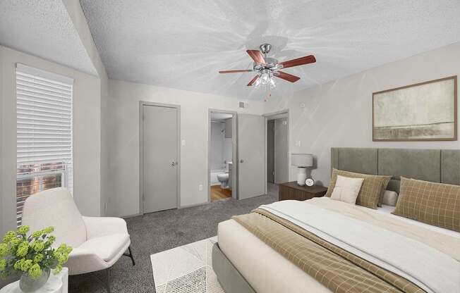 A bedroom with a bed, chair, and a ceiling fan.