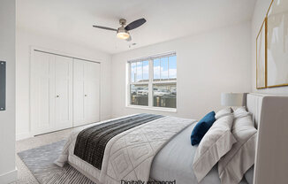a white bedroom with a large bed and a ceiling fan