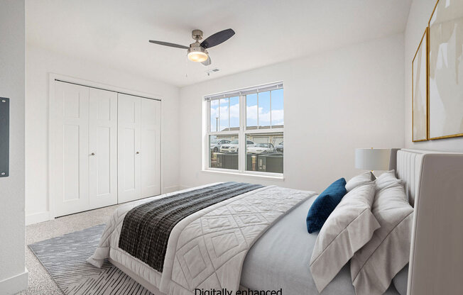 a white bedroom with a large bed and a ceiling fan