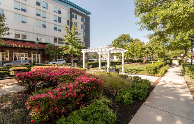 a sidewalk in front of a building with a white gazebo