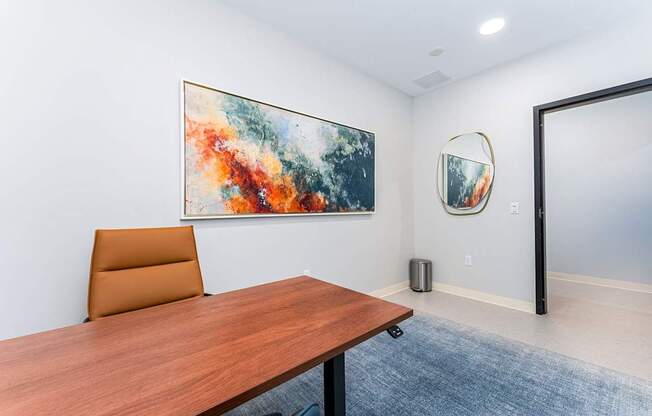 A conference room with a brown table and a painting on the wall.