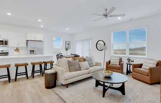 A living room with a white couch, a coffee table, and a ceiling fan.