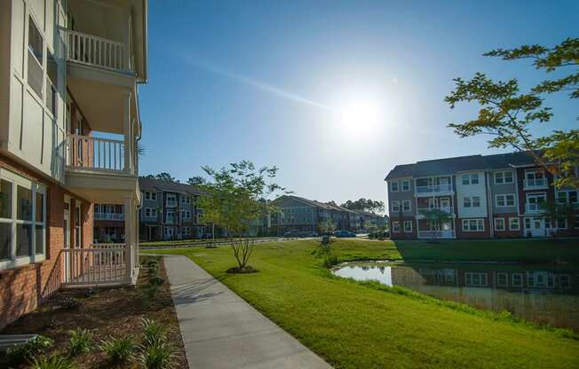 a sidewalk leading to a pond in front of a building