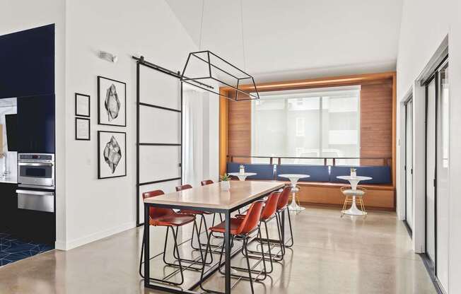 A modern dining room with a long table and chairs.