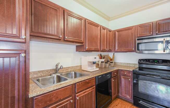 a kitchen with wood cabinets and black appliances