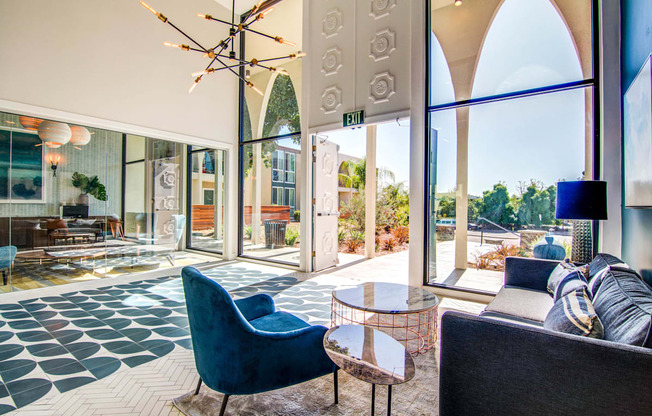 a living room with blue chairs and a chandelier  at Veranda La Mesa, La Mesa