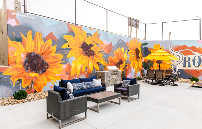 a patio with seating and a mural of sunflowers