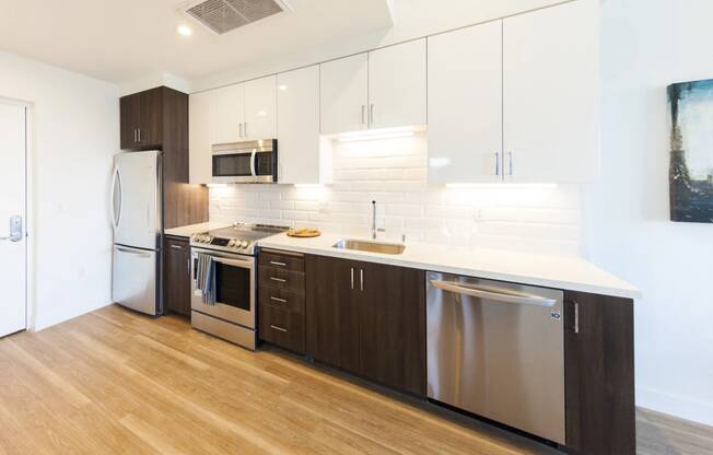 a modern kitchen with white cabinets and stainless steel appliances