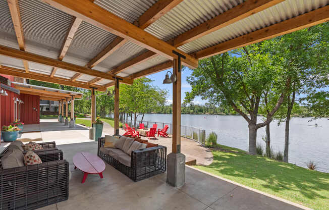 A patio with a table and chairs overlooking a lake.