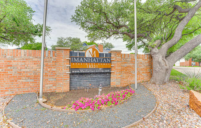 The entrance to a property with a sign that reads "The Manhattan" and a website address.