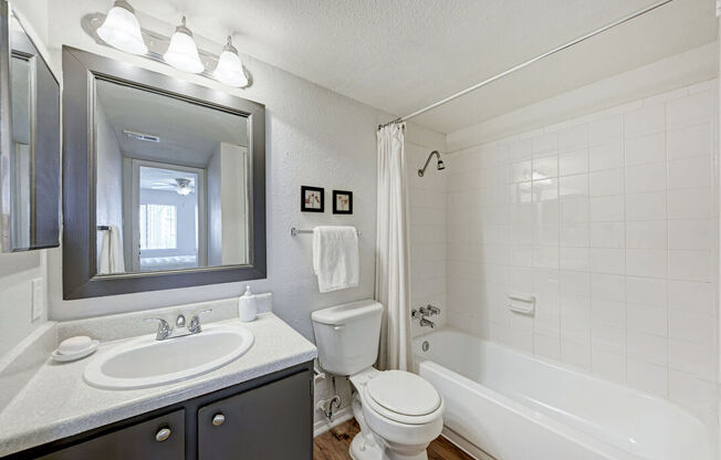 A white bathroom with a sink, toilet, and bathtub.