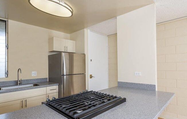 an empty kitchen with a stove and a refrigerator at Palms of Kilani Apartments, Wahiawa