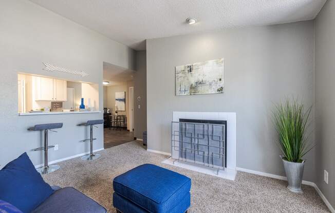 a living room with a fireplace and a kitchen with a bar