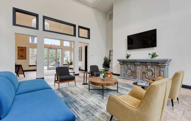 a living room with a blue couch chairs and a fireplace
