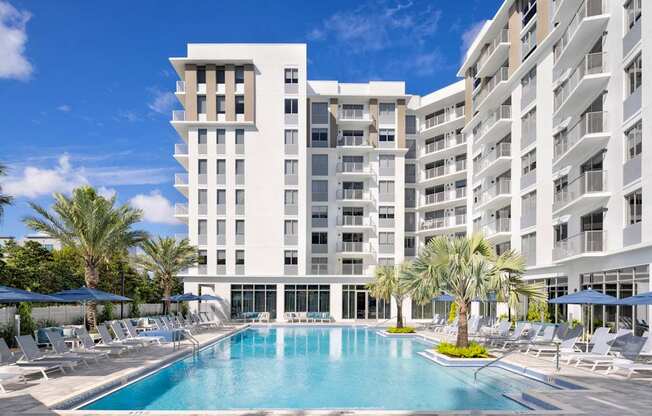 Expansive sun deck with heated pool and loungers at The Marc Apartments in Palm Beach Gardens FL