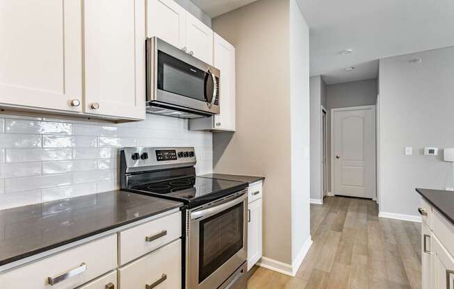 A kitchen with a stove top oven and microwave above it.