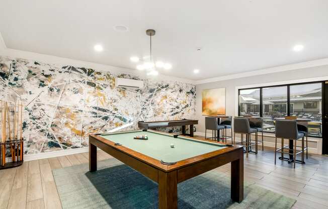 a pool table in a living room with tables and chairs at Crossgates Apartment Homes, Mississippi