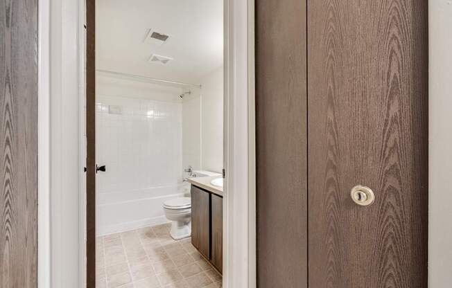 A bathroom with a toilet, sink, and mirror.