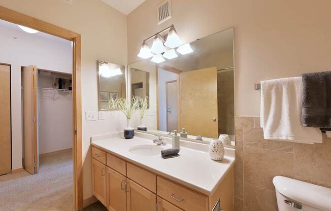 A bathroom with a vanity, a mirror, and a towel.
