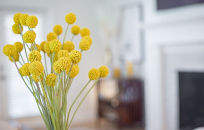 a vase of yellow flowers in a living room