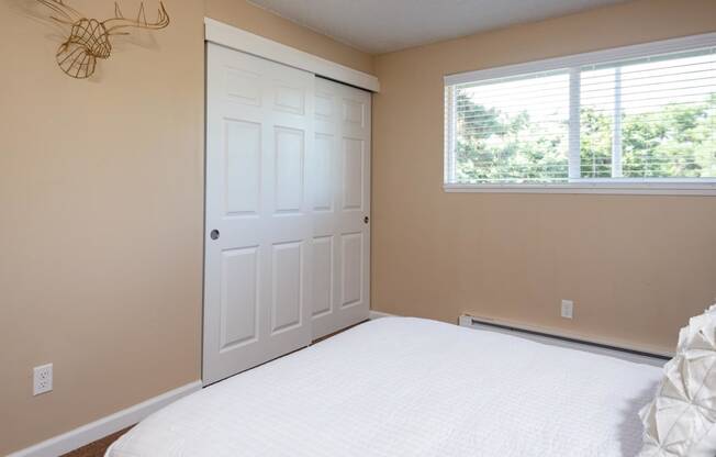 a bedroom with a bed and a white door and a window