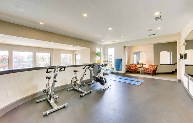 View of 2nd Floor Spin and Yoga Room, Showing Bikes, Mats, and Mirrors at Enclave on Golden Triangle Apartments