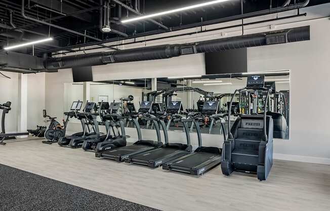 a row of cardio machines in a gym