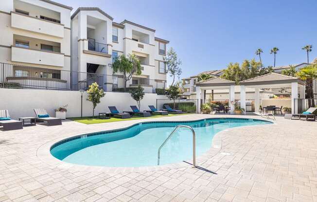 A swimming pool in a residential area surrounded by apartment buildings.
