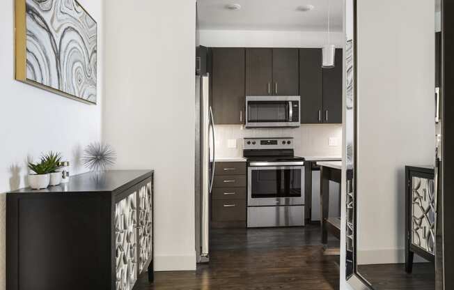 a kitchen with stainless steel appliances and dark wood cabinets