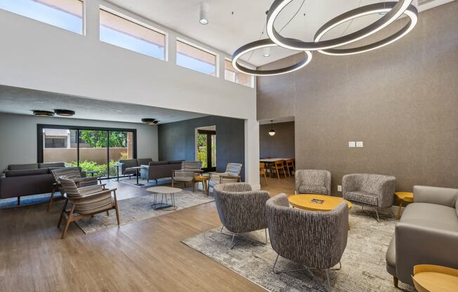 a large living room with chairs and tables and a large window at Acacia Gardens, Albuquerque, NM, 87111
