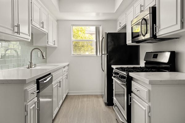 a white kitchen with a stove and a microwave at NOHO GALLERY Apartments, North Hollywood , CA 91601