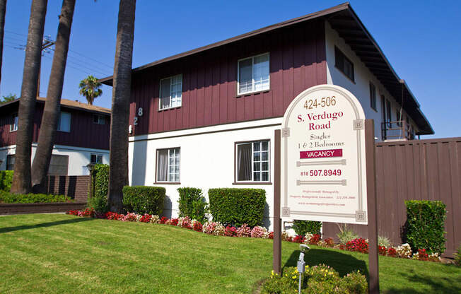 a red and white house with a sign in front of it