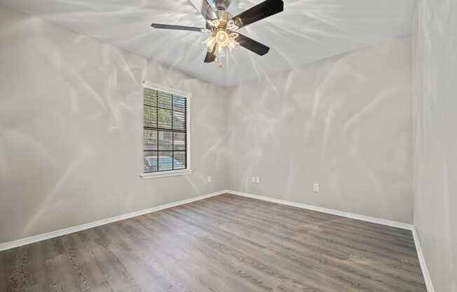 a bedroom with hardwood floors and a ceiling fan