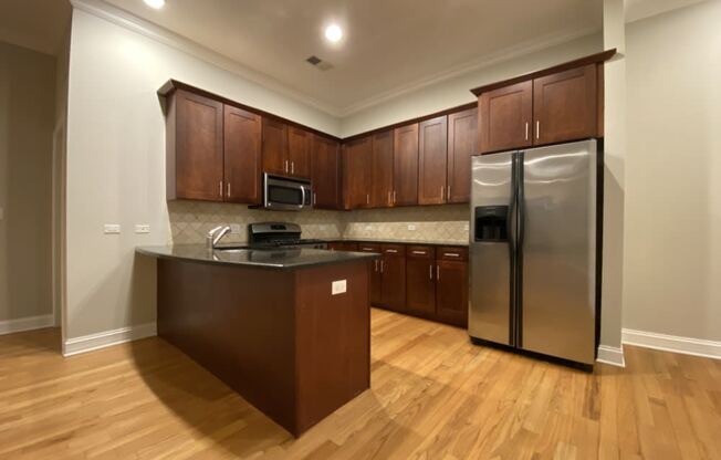 Kitchen with stainless steel appliances and tiled backsplash - 3 Bedroom