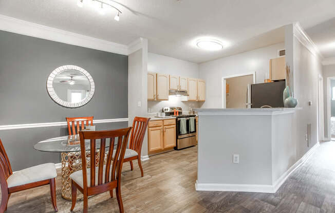A kitchen with a dining table and chairs.