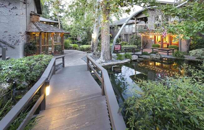 a wooden bridge over a pond in a garden