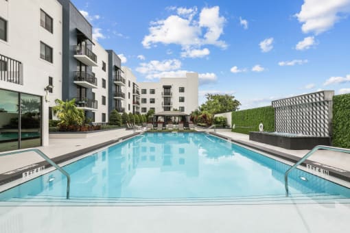 a swimming pool with an apartment building in the background