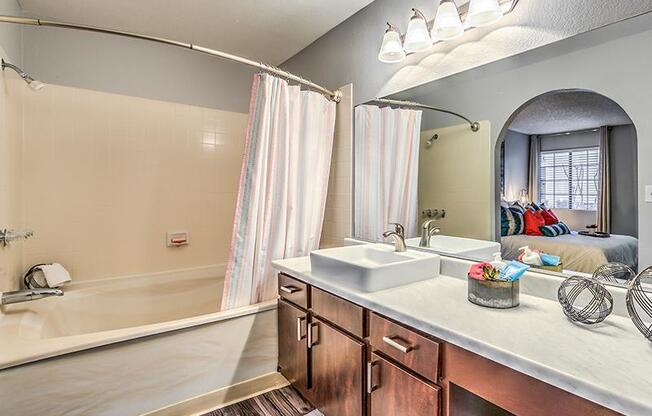 A bathroom with a white sink and a bathtub with a shower curtain.