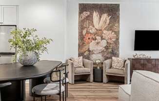 A living room with a large floral tapestry on the wall and a variety of seating options.